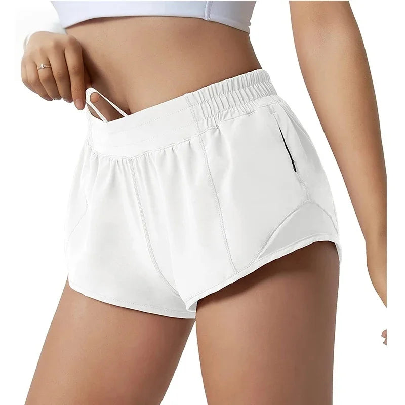 White women's high-waisted running shorts shown on a model's lower body.