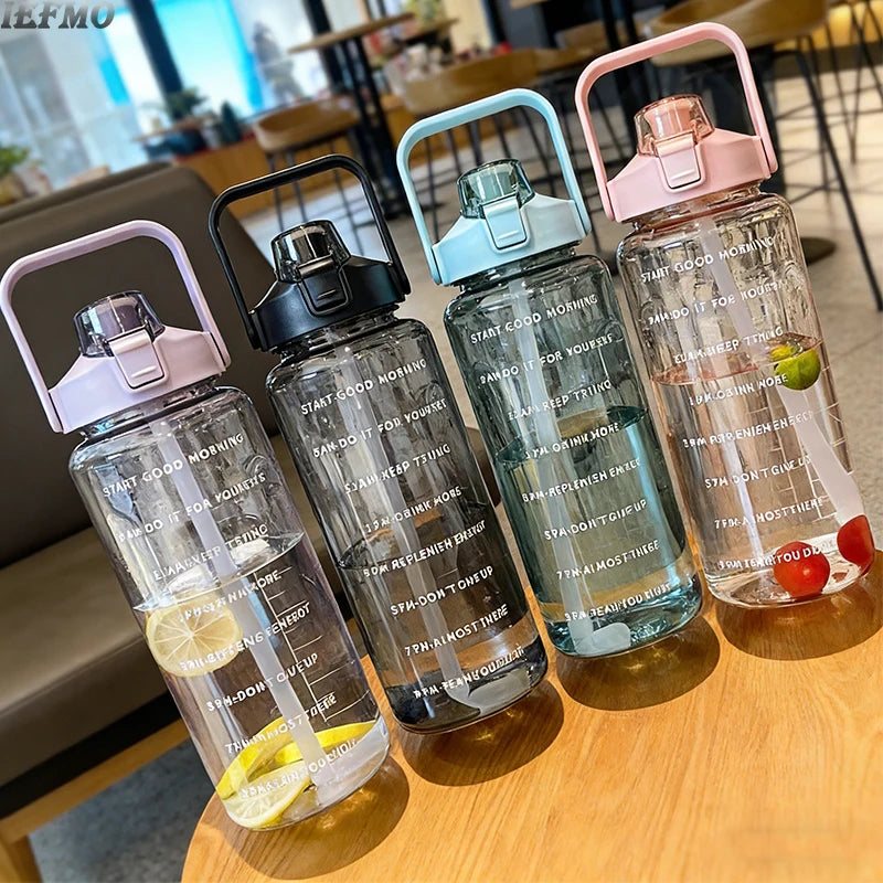Eine Sammlung langlebiger Tritan-Wasserflaschen in Pink und Türkis mit Zeitmarkierungen auf einem Holztable