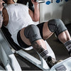 A person wearing black shorts and a white shirt is using a weight machine while wearing neoprene knee pads.