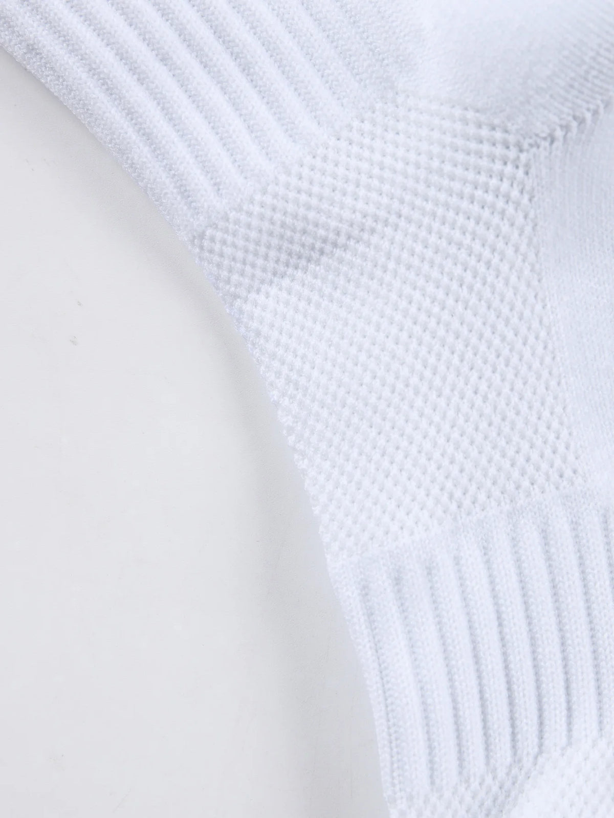 Close-up of white men's athletic soccer socks with a textured, ribbed design.