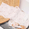 Primer plano de una diadema de encaje floral blanca sobre una estera tejida junto a ropa.