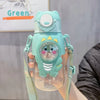 A hand holds a leak-proof cartoon dinosaur water bottle in mint green with a light blue lid and strap.