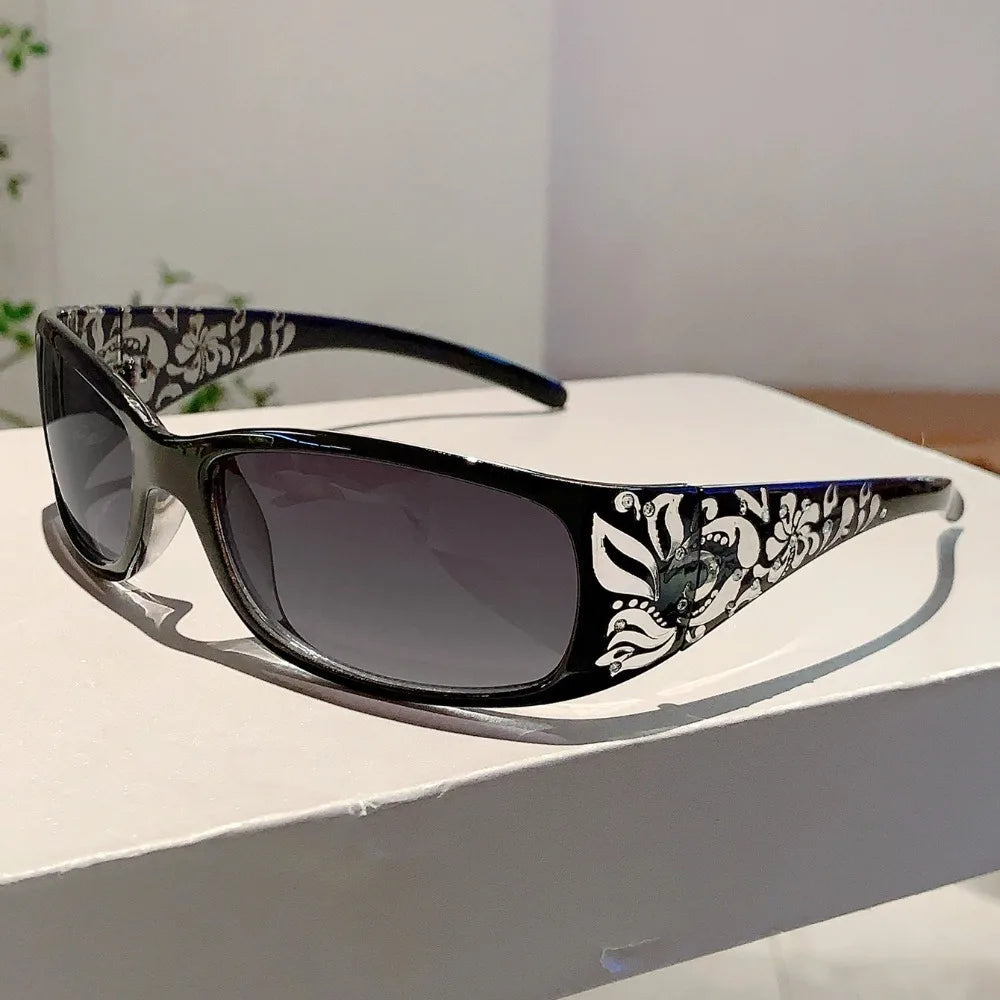 Black and white Y2K cat eye rhinestone sunglasses resting on a white surface.