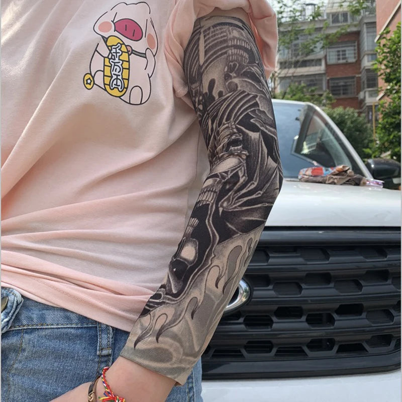 Una persona con una camisa rosa muestra un tatuaje de manga en su brazo, con arte oscuro y detallado.