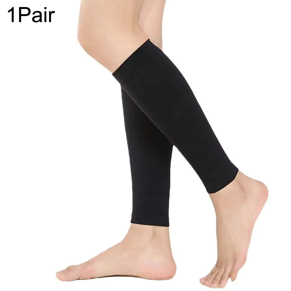 A pair of black calf compression sleeves worn on a person's lower leg.
