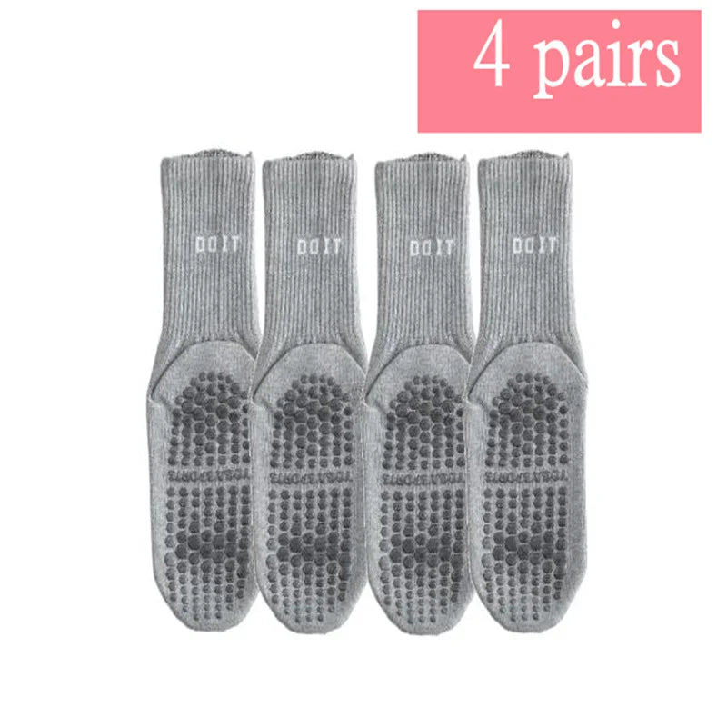 Vier Paar grauer atmungsaktiver rutschfester Yoga- und Fitnesssocken nebeneinander.