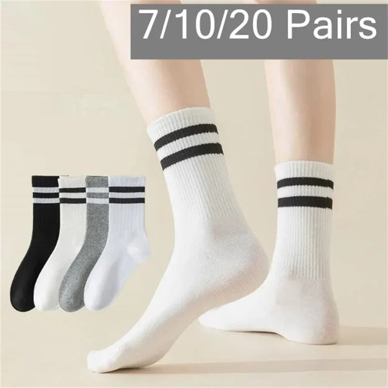 Une paire de chaussettes en tricot blanches avec des rayures noires sur la cheville et le mollet, affichées sur la jambe d'un