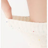 Close-up of white five-finger yoga socks being worn on a person's leg.