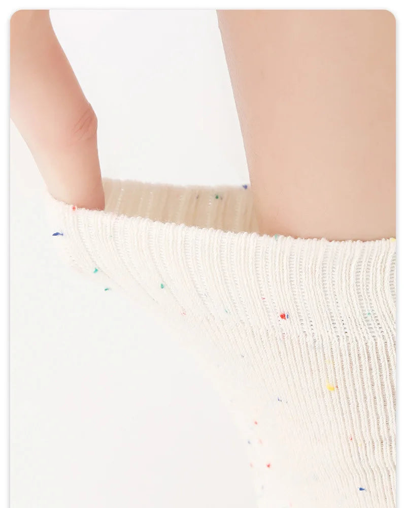 Close-up of white five-finger yoga socks being worn on a person's leg.