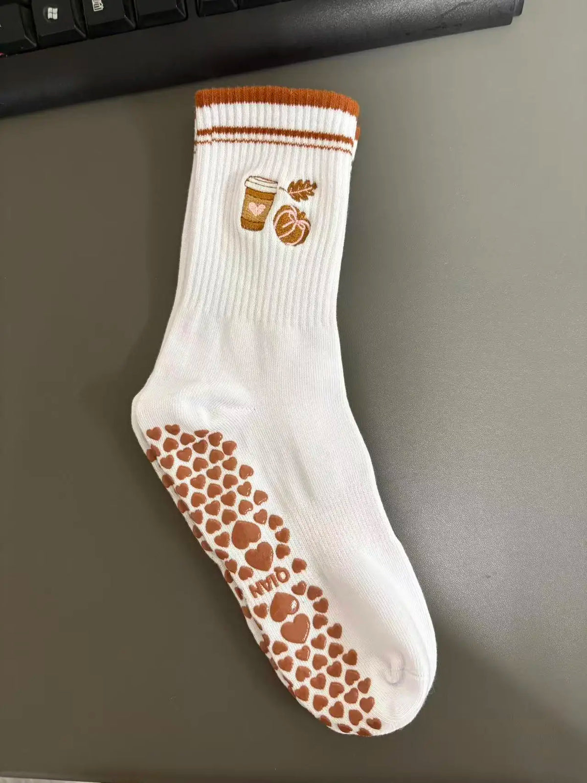 Weiße Strick-Yoga- und Fitnesssocken mit braunen Akzenten und Herzmuster.