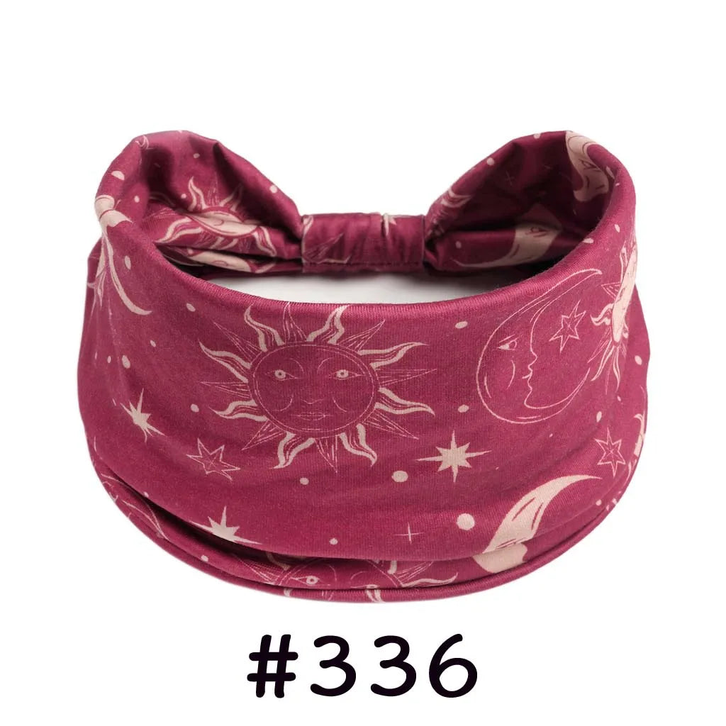 A deep magenta boho knotted cotton headband featuring celestial designs like the sun and moon.