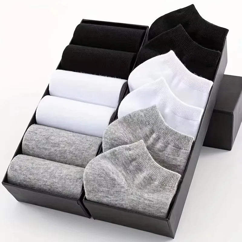 Caja negra con pares de calcetines unisex de algodón transpirable en blanco, gris y negro.