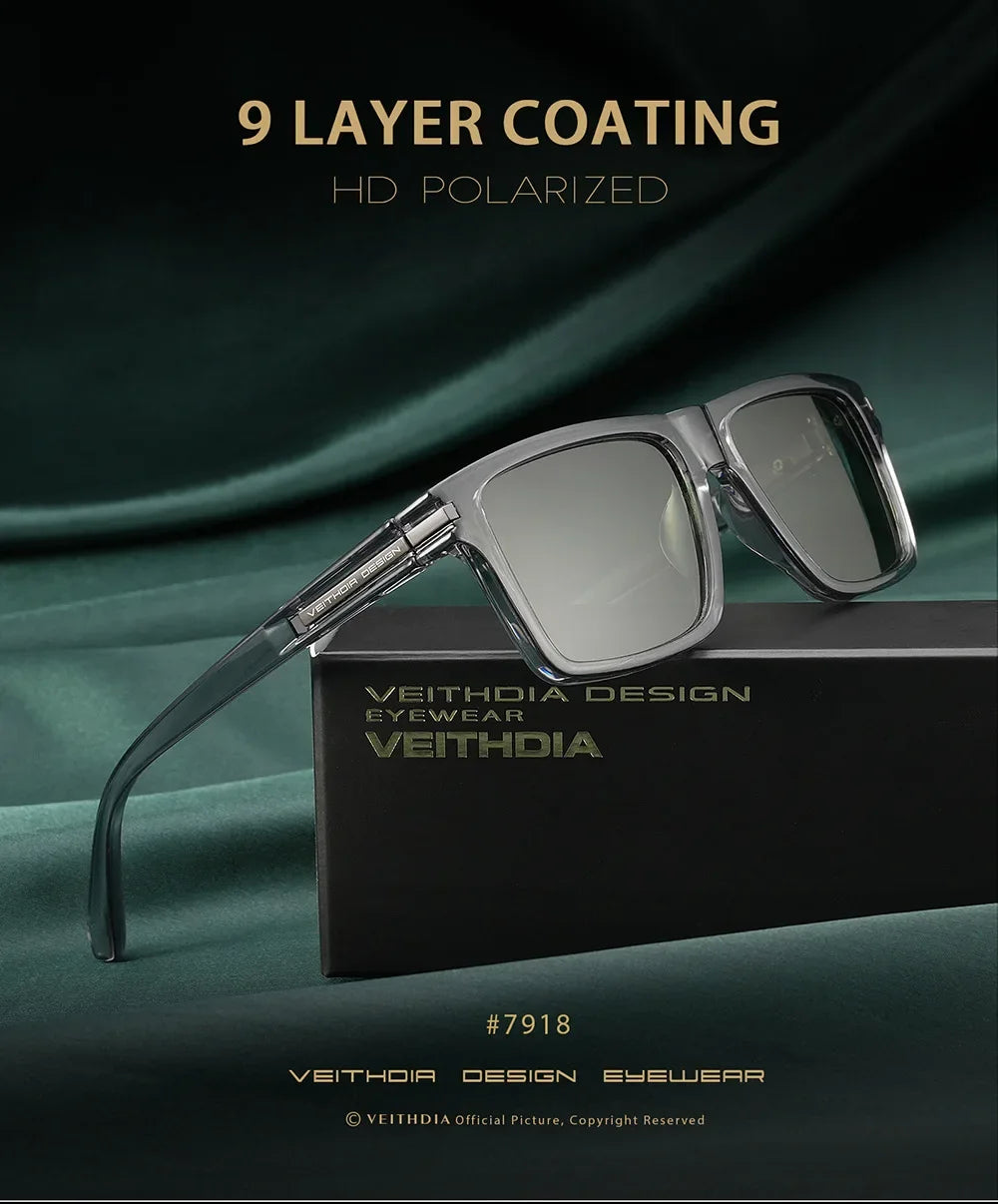 A pair of silver-framed, square polarized sunglasses resting on a black box with branding.