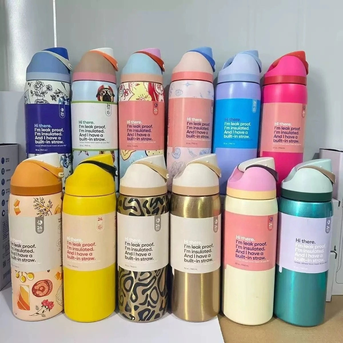 A collection of colorful insulated stainless steel sports water bottles lined up on a white surface.