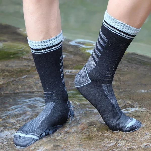 A pair of black and gray waterproof breathable hiking socks worn on a person's leg.
