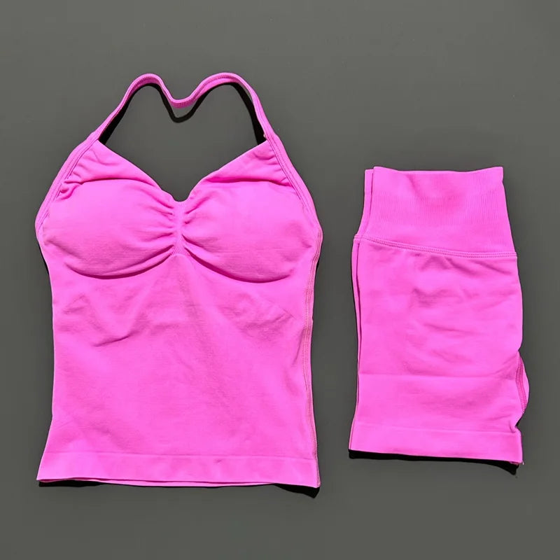 A bright pink women's seamless backless fitness set top and leggings displayed against a gray background.