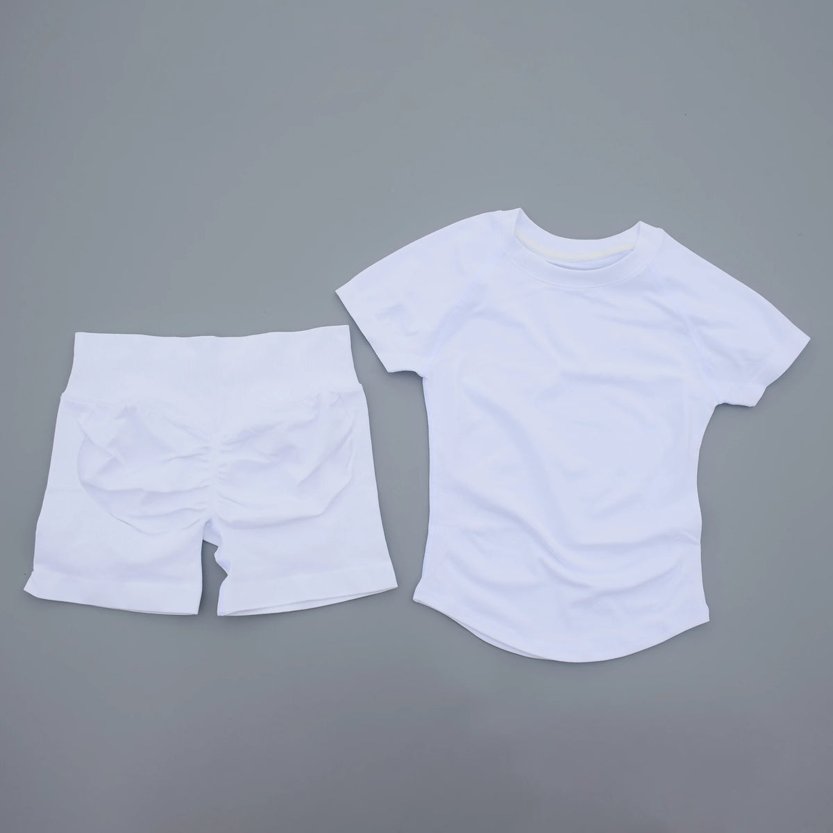 Ensemble de yoga et fitness blanc sans coutures pour femmes, composé d'un t-shirt et d'un short.