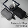 A gray cosmetic bag and a black travel bag are displayed with a framed mirror and makeup tools.