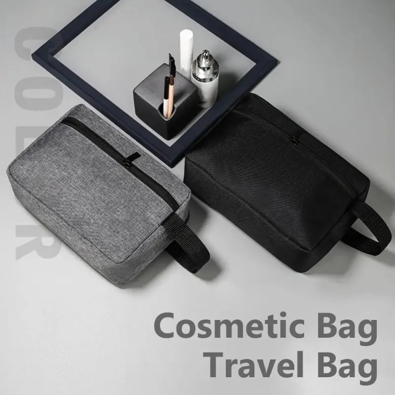 A gray cosmetic bag and a black travel bag are displayed with a framed mirror and makeup tools.