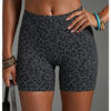 Un mannequin porte des shorts de yoga à taille haute à imprimé léopard et un bracelet en or.