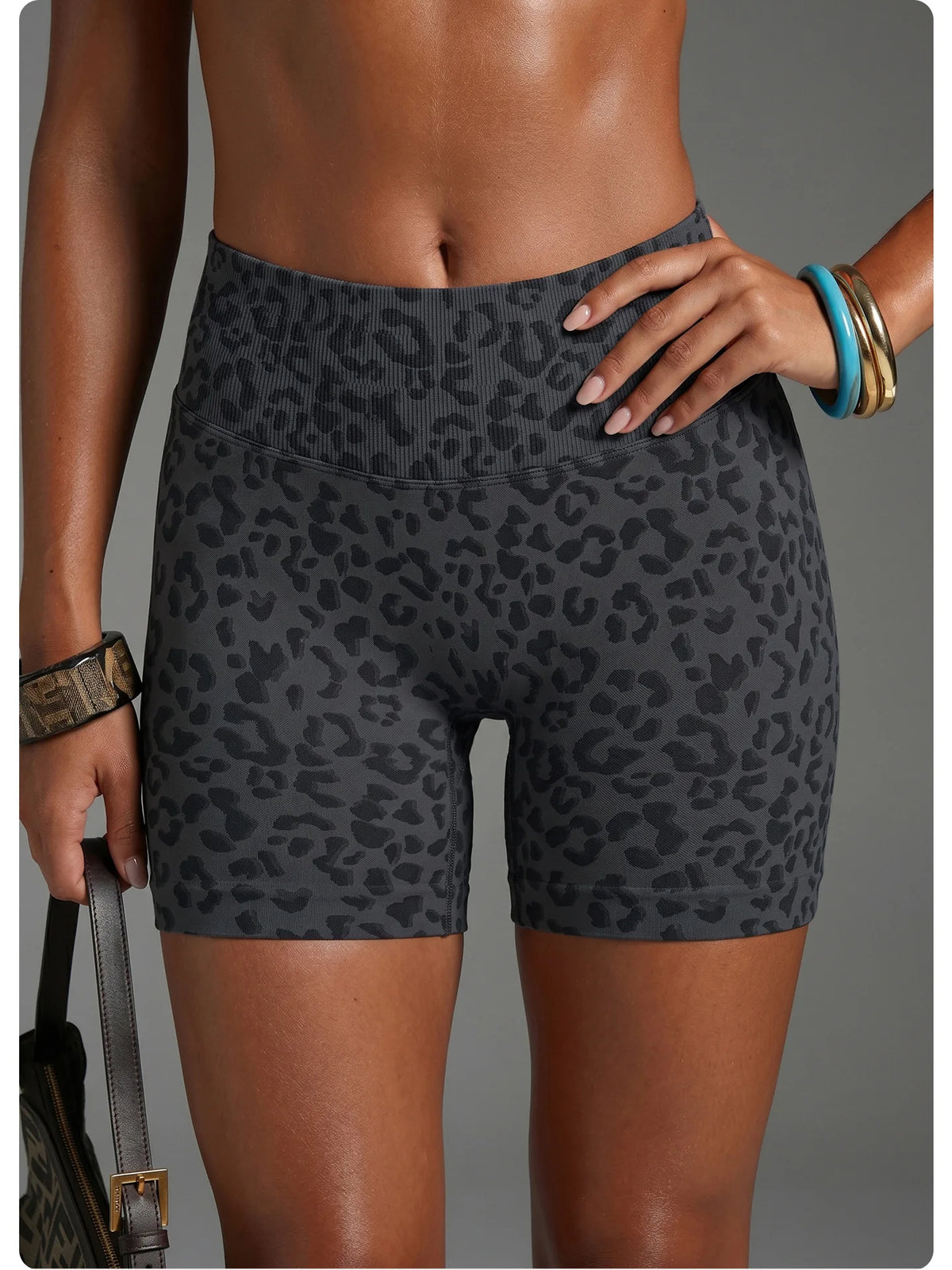 Un mannequin porte des shorts de yoga à taille haute à imprimé léopard et un bracelet en or.