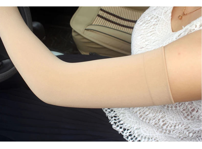 A close-up of a person wearing beige breathable arm sleeves on their forearm.