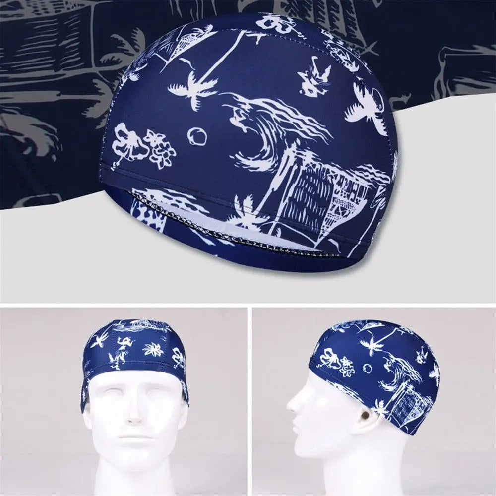 Casquette de bain en nylon élastique bleu foncé imprimée de silhouettes blanches de plantes et de faune tropicales.