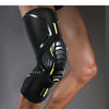 A black compression knee brace with yellow accents is worn on a person's leg.