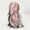 Elegant satin square scarf featuring a floral design in pink and gold tones