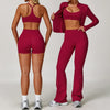 A woman models a maroon 3-piece yoga sports set consisting of a cropped top, shorts, and leggings.
