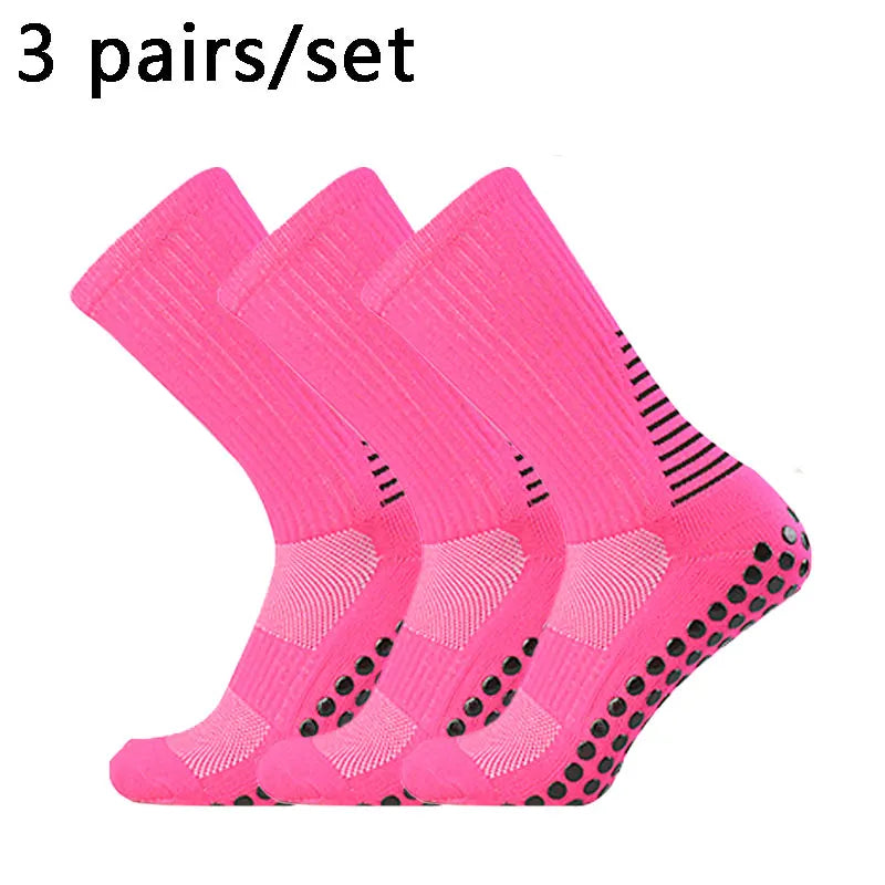 Three pairs of bright pink performance football socks laid out for display