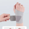 Una mano lleva una férula gris para anillos de doble presión para proporcionar una articulación sólida y estable.