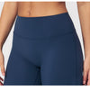 A close-up of a navy blue women's high-waist flared yoga pant worn by a model.