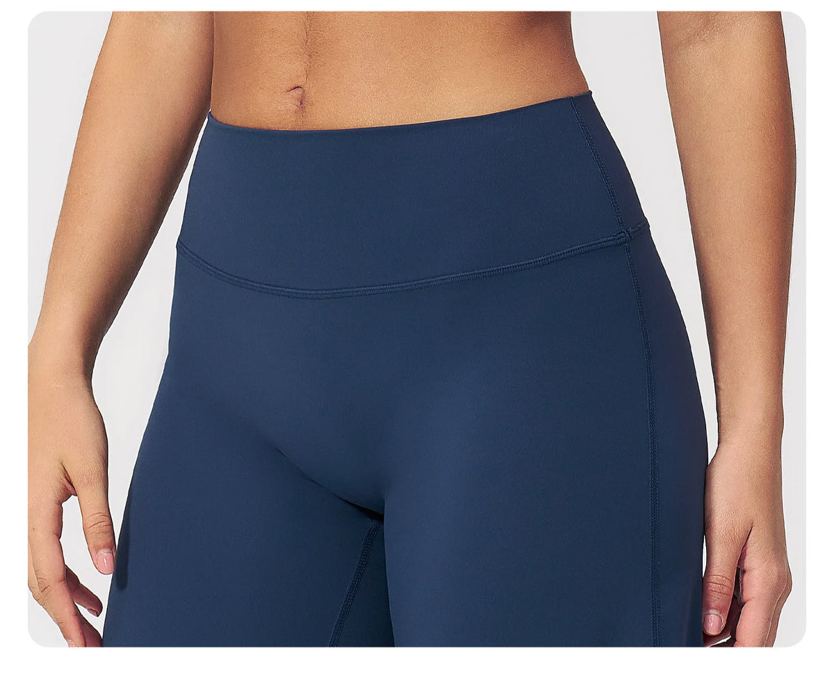 A close-up of a navy blue women's high-waist flared yoga pant worn by a model.