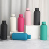 A collection of double-layer vacuum thermos cups in pink, black, and teal colors displayed on a white surface.
