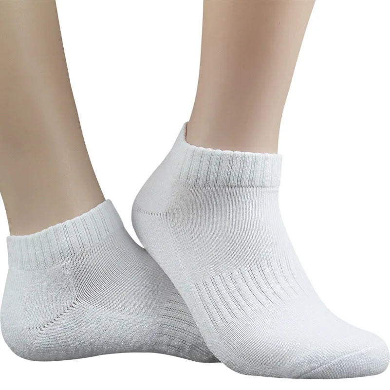 Un par de calcetines deportivos blancos de algodón para el tobillo mostrados en un pie.