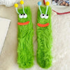 Pair of bright green fuzzy knit socks with cartoon face designs