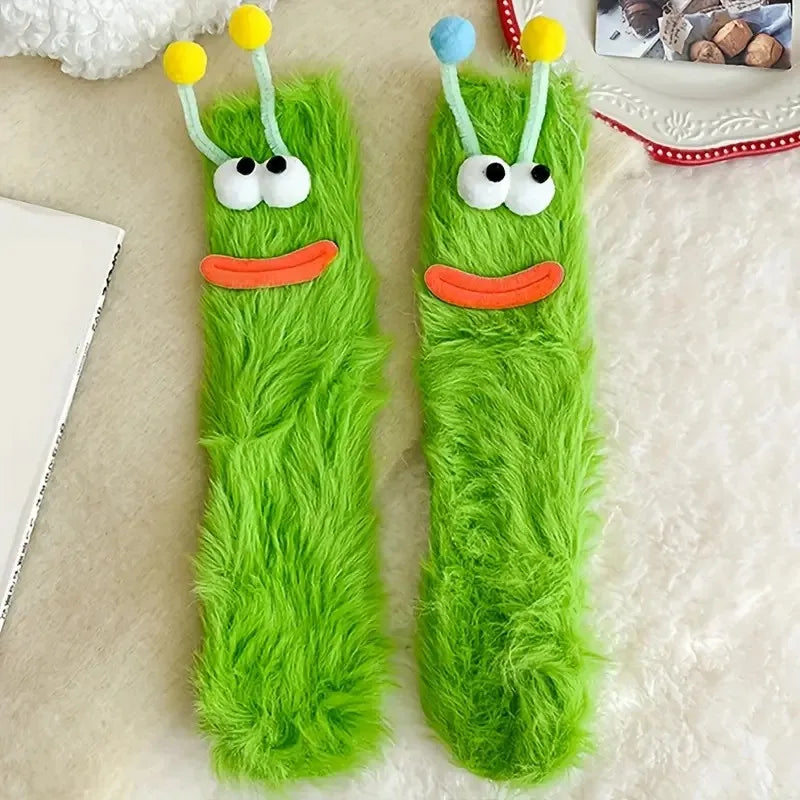 Pair of bright green fuzzy knit socks with cartoon face designs