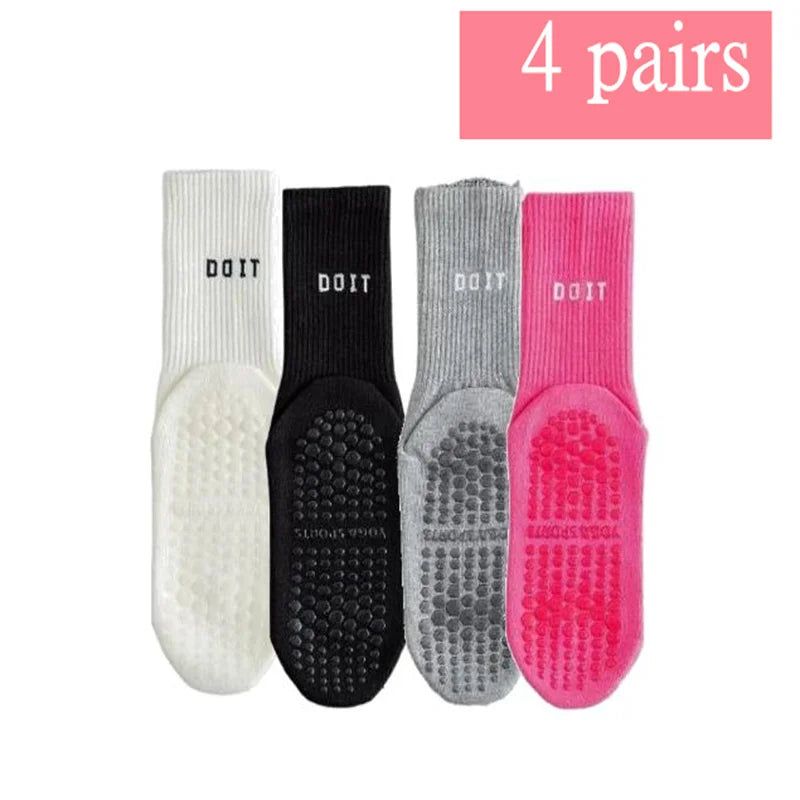 Vier Paar atmungsaktiver rutschfester Yoga- und Fitnesssocken in Weiß, Schwarz, Grau und Pink.
