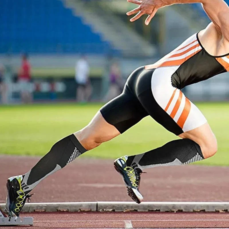 A man wearing compression socks is running on a track, showing the athletic wear in action.