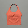 A seamless performance yoga and gym tank top in a coral orange color displayed against a gray background.