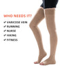 A pair of beige medical compression stockings being worn on legs.