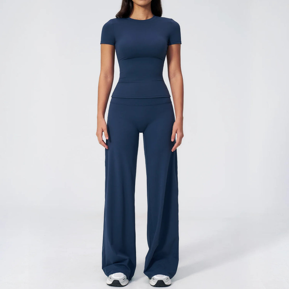 A woman wearing a navy blue women's premium fitness tracksuit top and matching pants.