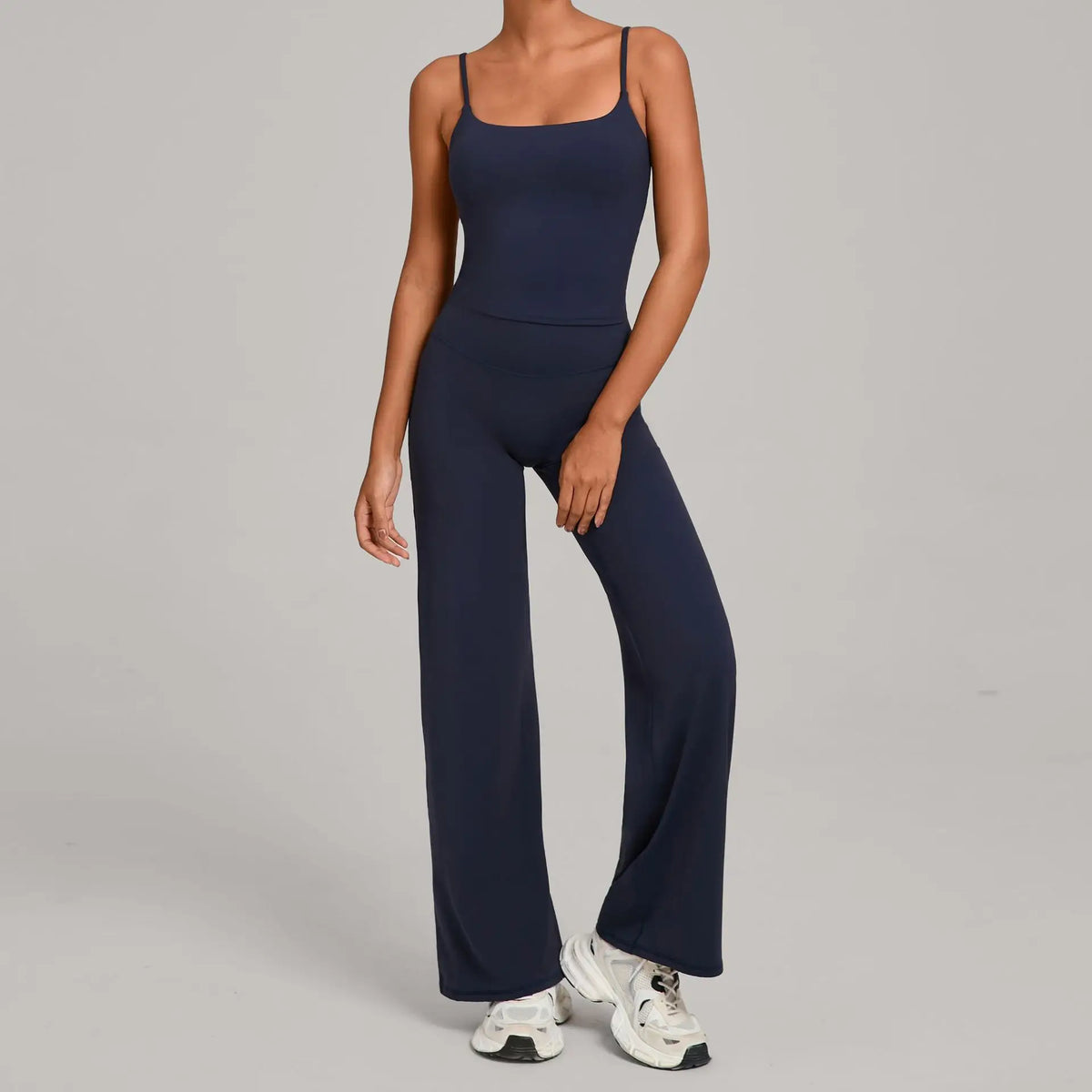 A woman wearing a navy blue high-waist yoga and fitness tracksuit set with matching top and pants.