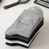 A stack of five gray, black, and white bamboo fiber socks lying on a white surface.