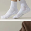 White breathable sports performance socks worn on a person's feet and ankles.