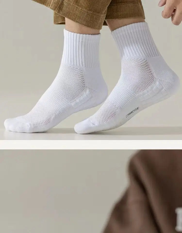White breathable sports performance socks worn on a person's feet and ankles.