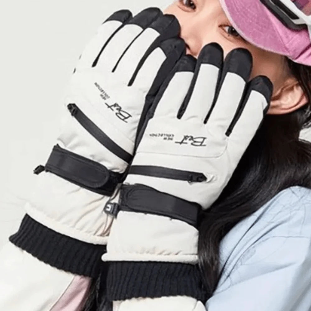Close-up of a person wearing white and black thermal winter ski gloves with pink accents.