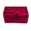 A deep red women's elastic sports headband folded into a knot.
