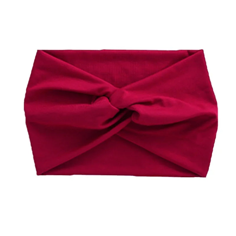 A deep red women's elastic sports headband folded into a knot.